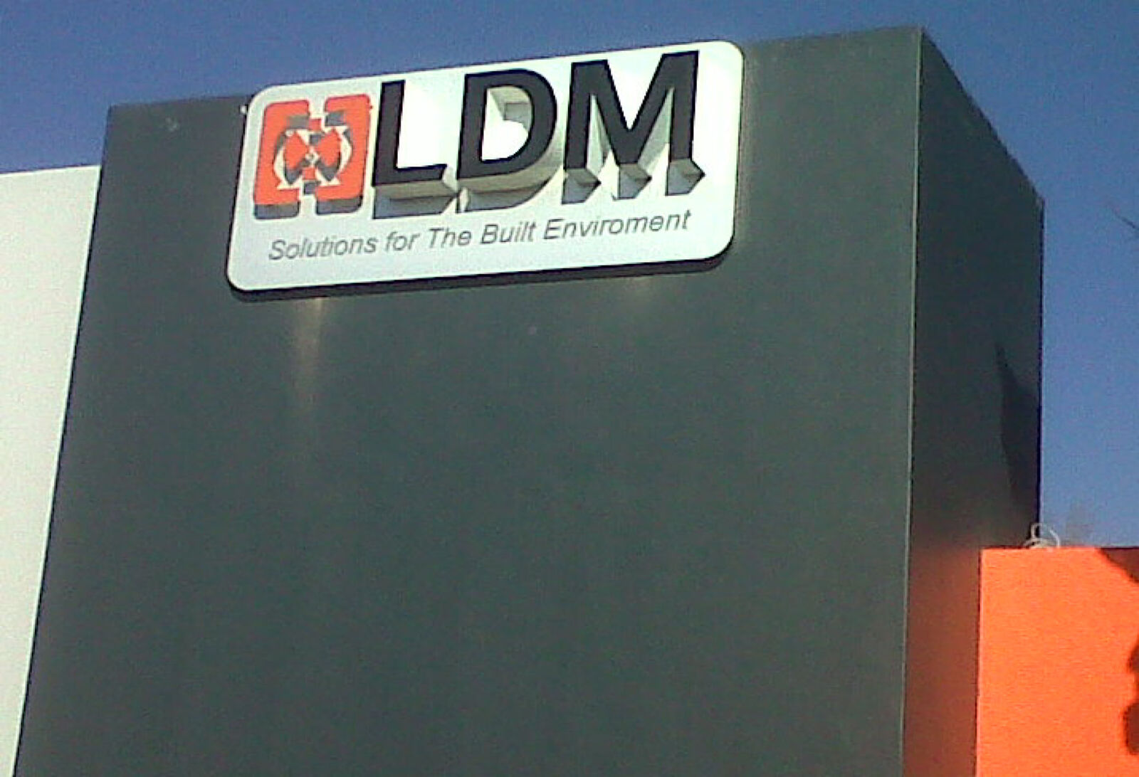 LDM branded building sign panel mounted high on a dark facade
