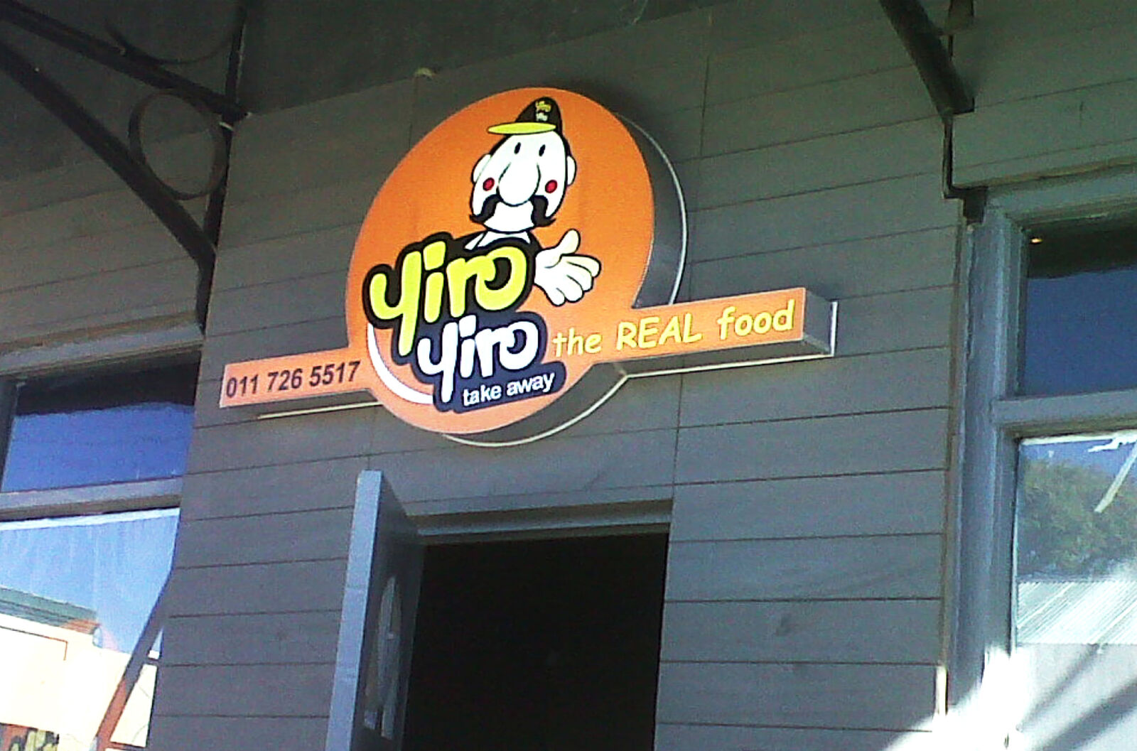 Yiro Yiro shaped shopfront sign board mounted above a takeaway entrance